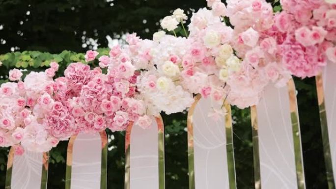 美丽的婚礼装饰。夏季阳光明媚的婚礼当天鲜花婚礼拱门。鲜花婚礼装饰品