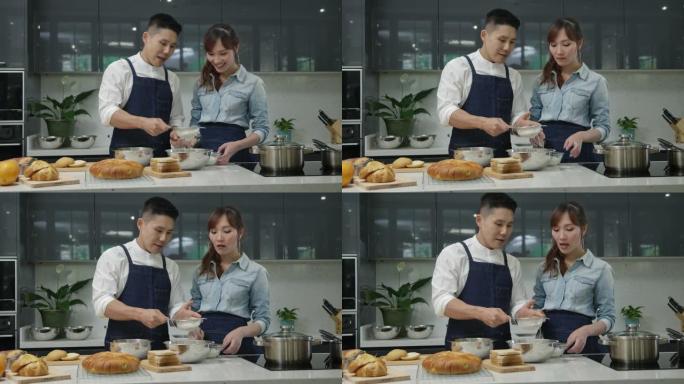 年轻的亚洲妻子和丈夫跳舞，并努力在厨房里一起做饭。