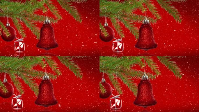 红色背景下悬挂在树枝上的圣诞装饰品上的雪