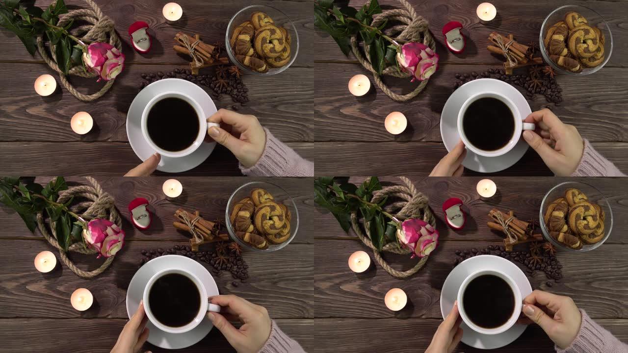 一个女人放下杯子，在浪漫装饰的桌子上拿起一杯咖啡。情人节