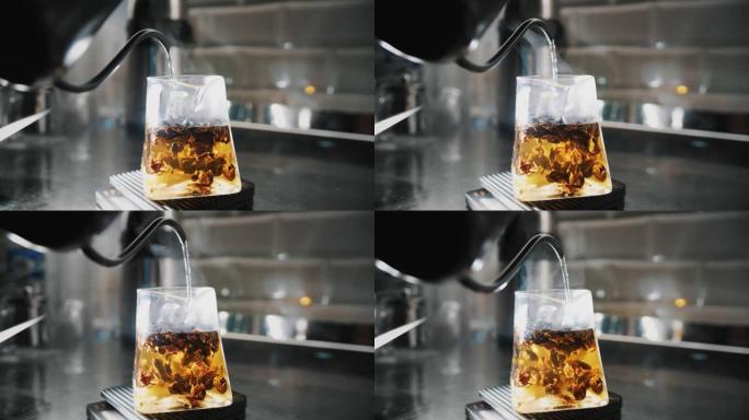 茶饮料。特制果茶。特写。茶师将沸水倒入不同成分的玻璃茶壶中。不含咖啡因的热饮