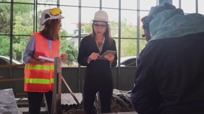 两名使用平板电脑的亚洲女性建筑工程师在建筑工地车间检查工作。