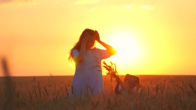 在公园里一起散步，日落很美。妈妈和女儿在夏天的田野里很开心。穿着白色连衣裙，一个女人和一个女孩对着镜