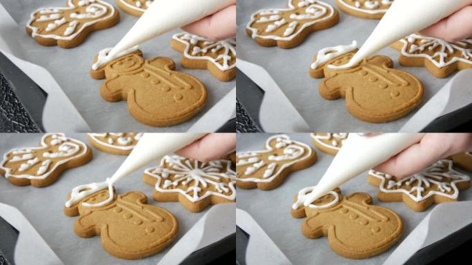 圣诞节日姜饼饼干。女性手工装饰糕点袋，家庭厨房配有甜白色糖衣雪人形饼干