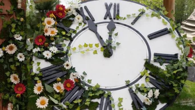 田野上盛开的大挂钟，显示时间11:55，12:00。时间管理理念，夏令时。春天或婚礼。妇女节野餐