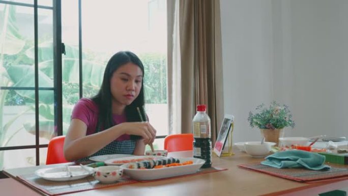 东南亚女人在家做寿司卷。