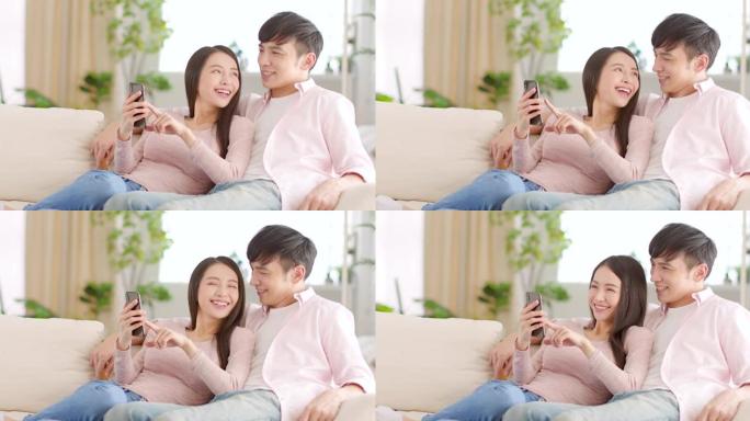 幸福的年轻夫妇在家里的客厅看手机