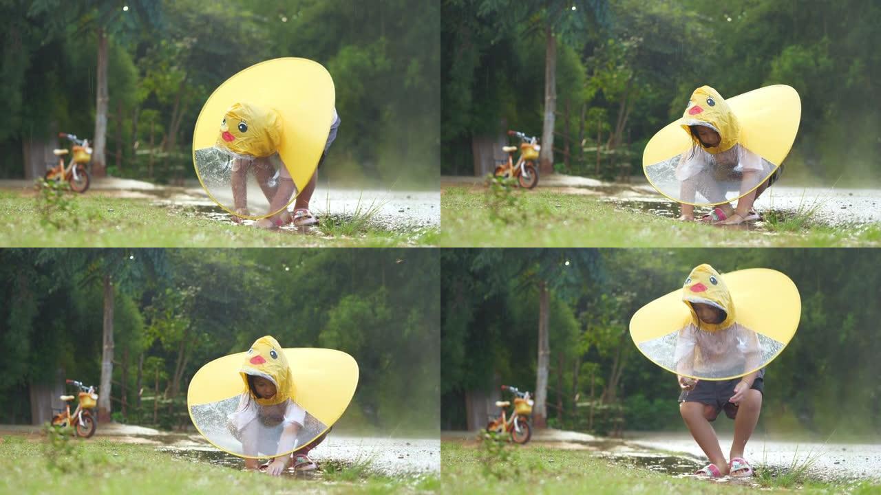 亚洲小女孩在雨中玩水。