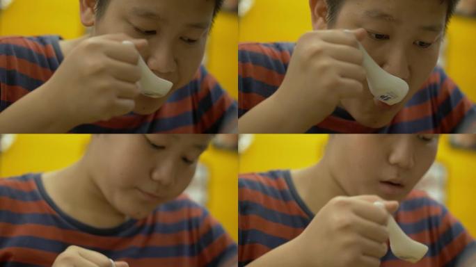 快乐的亚洲男孩和家人一起在日本餐厅享受他的食物，生活方式理念。