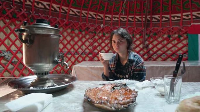 女人在茶炊的蒙古包里喝茶