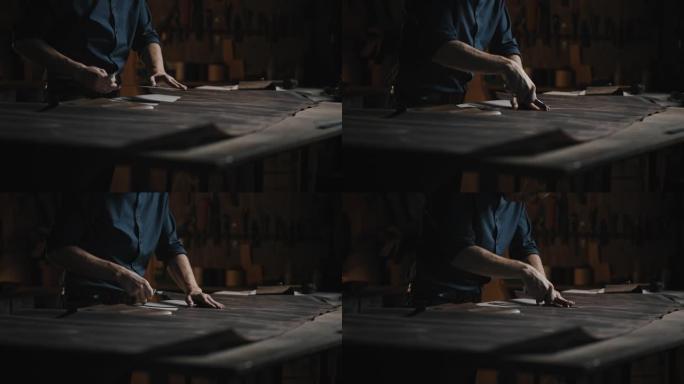 无法识别的男人裁缝在车间切割皮革的特写镜头，为制鞋准备坯料
