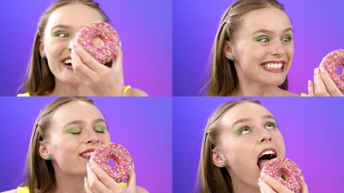 一个迷人女孩吃粉红色甜甜圈的肖像