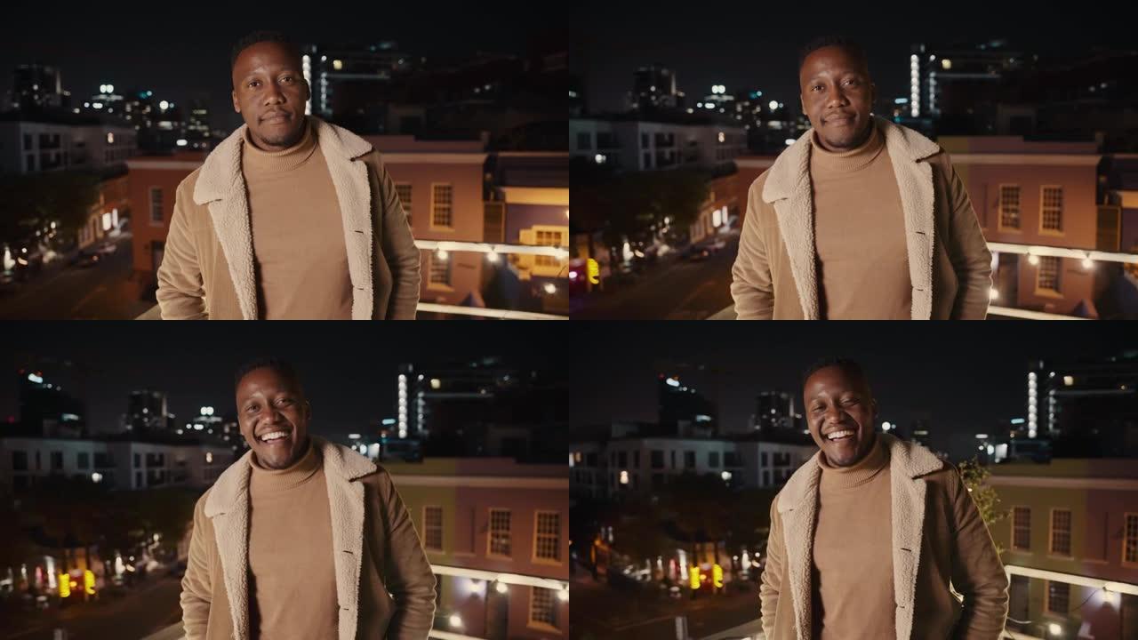 黑人男性站在城市的屋顶上，在夜晚欢快地微笑。高质量4k镜头