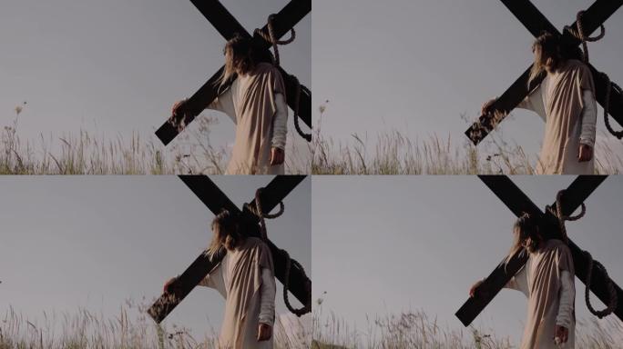 耶稣肩膀上站着十字架。风在吹。草在swways