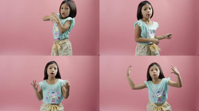 小女孩在粉色背景上听音乐和跳舞。