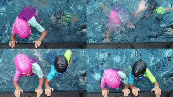 兄弟姐妹两个兄弟姐妹在游泳池边上下潜水，在水下练习屏住呼吸。