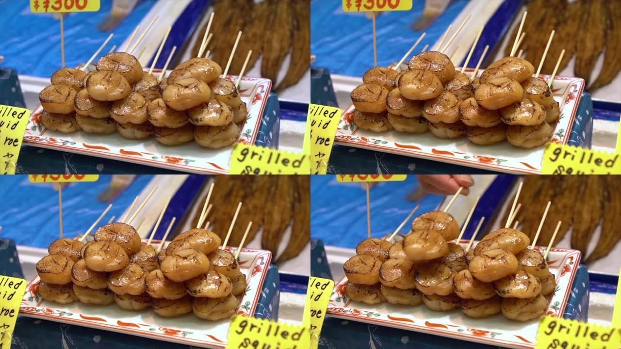 吃热食生鱼片。商人在西木鱼市场出售美味的扇贝。