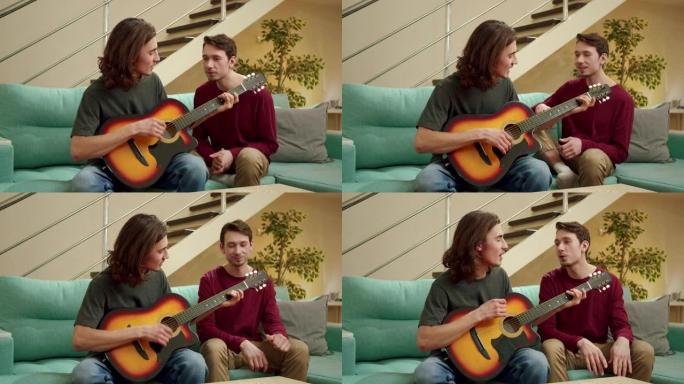 一个年轻人正在为他的朋友弹吉他，他们俩都在唱歌