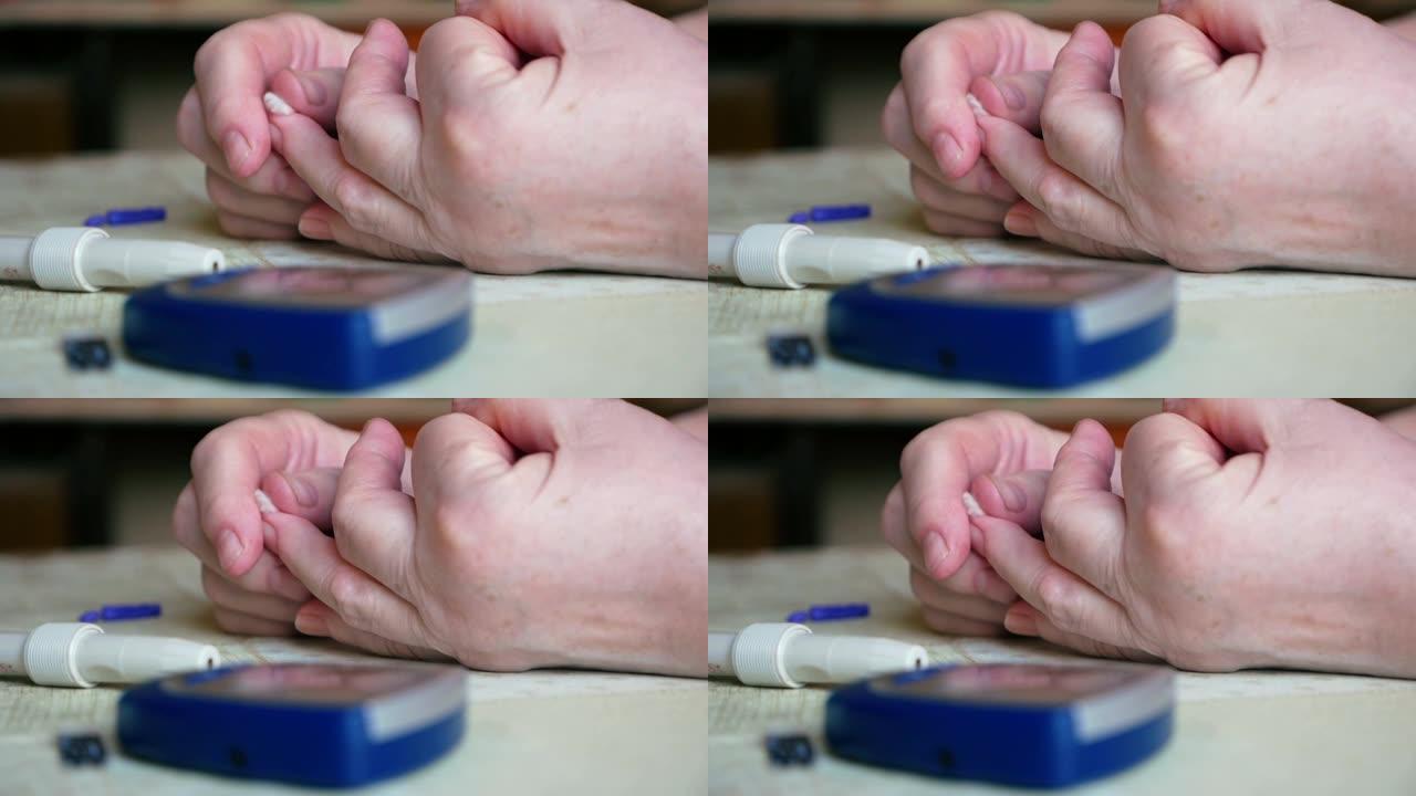 在家里用血糖仪进行血液检查后，糖尿病患者的手特写。仪表不在桌子上。女人用棉签止住手指上的血。