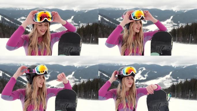 年轻女孩滑雪者在山顶上微笑