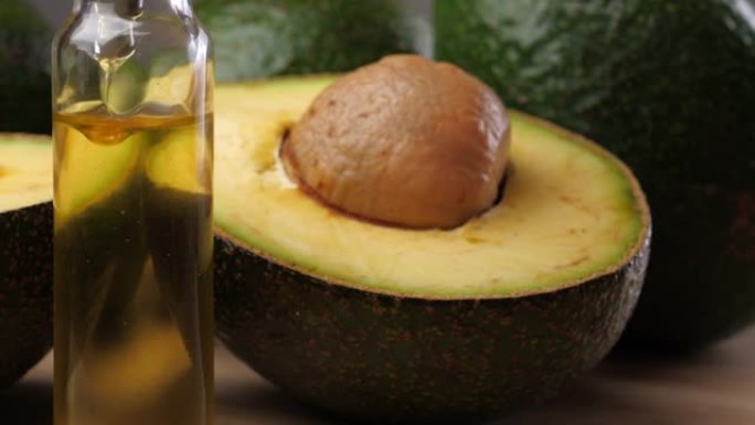 木桌上的鳄梨油和鳄梨水果。鳄梨是一种营养丰富的水果。