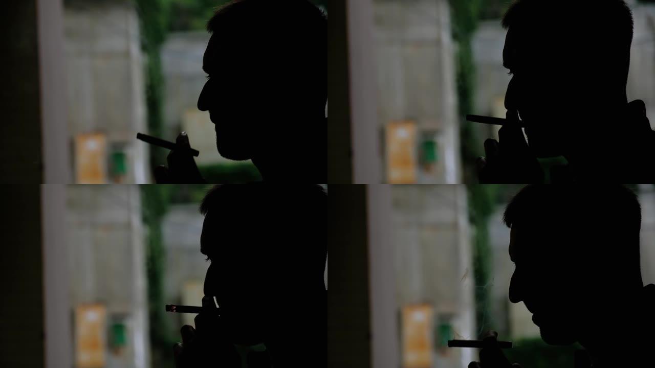 一个男人在户外抽烟的剪影晚上关闭