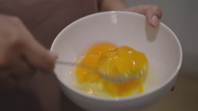 用叉子准备和混合鸡蛋煮炒鸡蛋