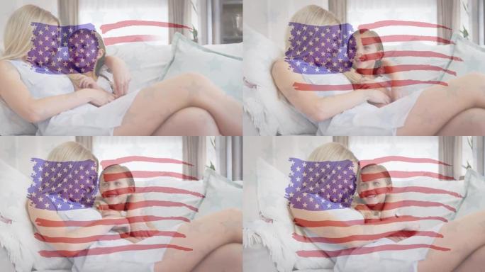 美国国旗动画向坐在沙发上微笑的白人母亲和女儿挥手