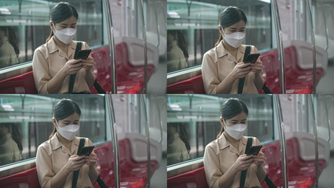 乘火车旅行时使用智能手机的亚洲妇女