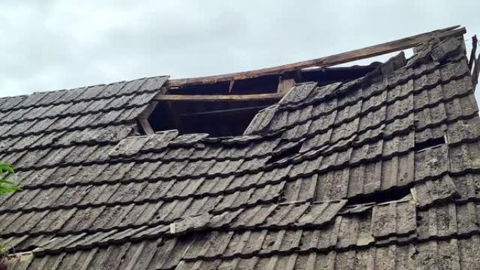 旧瓷砖屋顶有一个大洞。破碎的屋顶