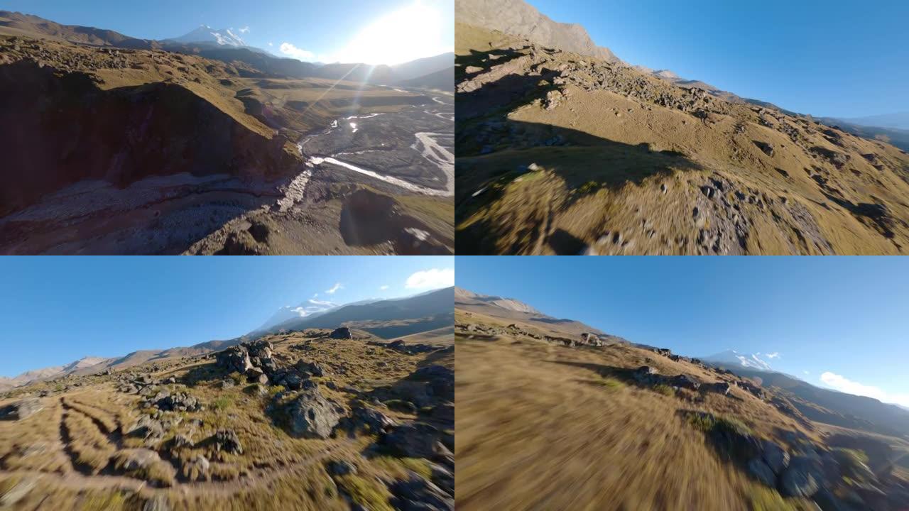 山上的四轴飞行器在地面上方低空扫射并拍摄山脉景观。非常漂亮的镜头