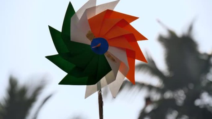 一个印度三色针轮或纸扇在蓝天下旋转的特写镜头