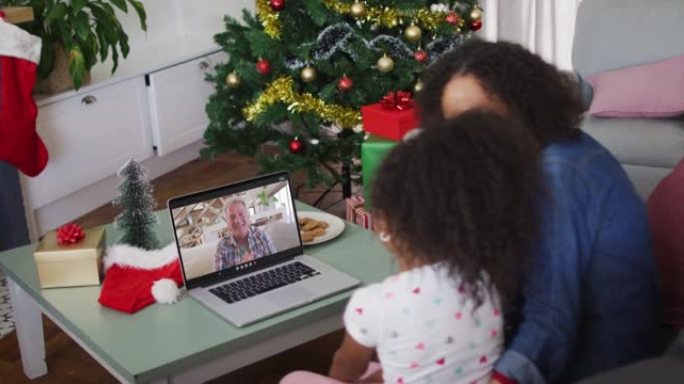 圣诞节期间，非裔美国母女在家里的笔记本电脑上进行录像