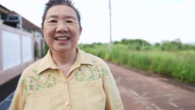 快乐的老年妇女走向镜头，微笑着友好的脸上带着皱纹，热情善良的老年人，老年保健和放松运动的肖像，祖母享