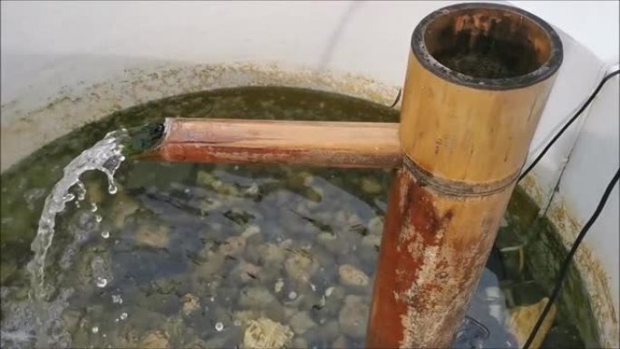 水从浴缸中的竹筒流出