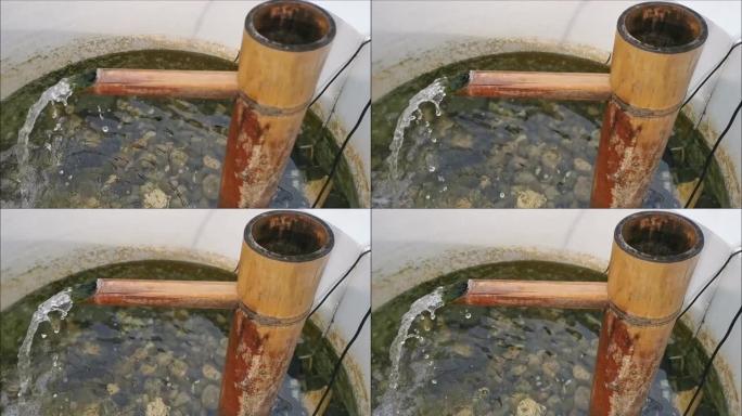 水从浴缸中的竹筒流出
