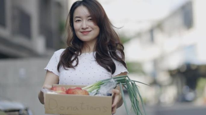 亚洲女志愿者将食物放入捐款箱