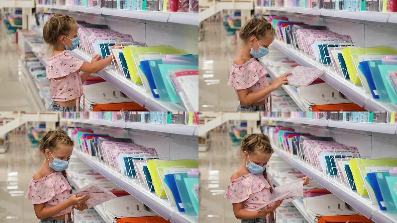 一个小女孩戴着医用面具站在书店里看书。图书馆里的孩子。