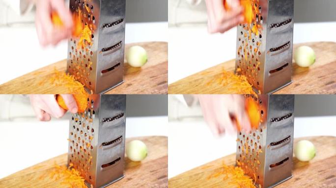 胡萝卜在切木板上的刨丝器上摩擦。