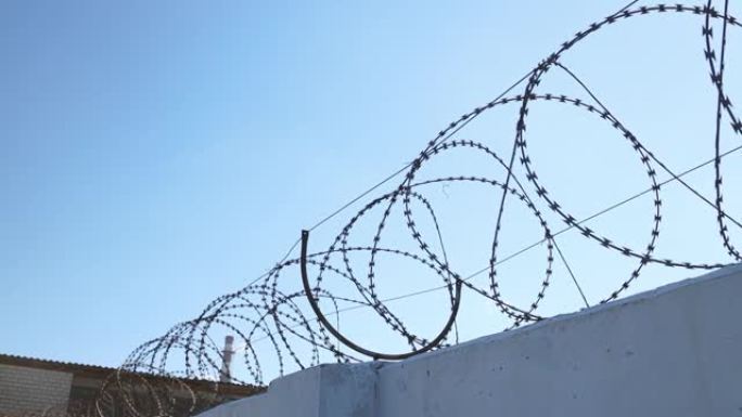 混凝土墙和带刺铁丝网，防止移民。监狱的概念。倒钩铁丝安全边界。