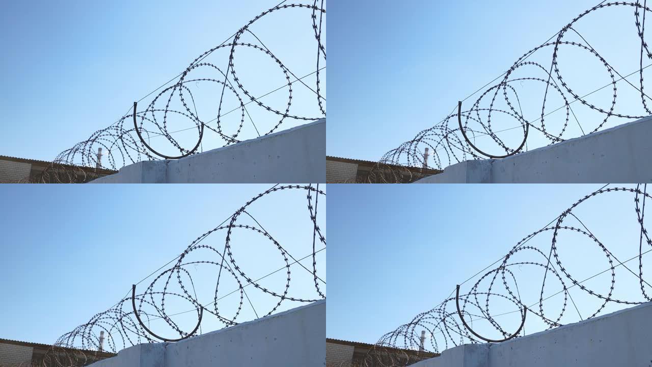 混凝土墙和带刺铁丝网，防止移民。监狱的概念。倒钩铁丝安全边界。