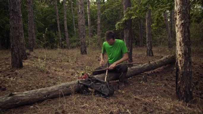 一个徒步旅行者在森林里用干燥的树林建造一个避难所