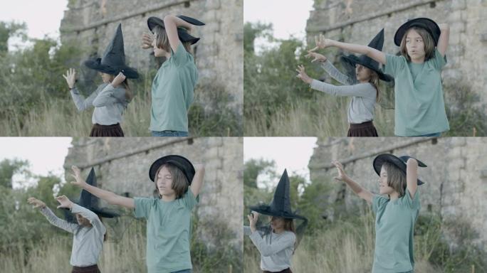 男孩和女孩在自然界中的巫婆帽子中变戏法的侧视图