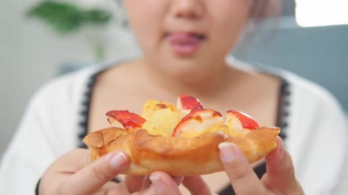 特写丰满的亚洲女人带着欲望看着披萨的嘴