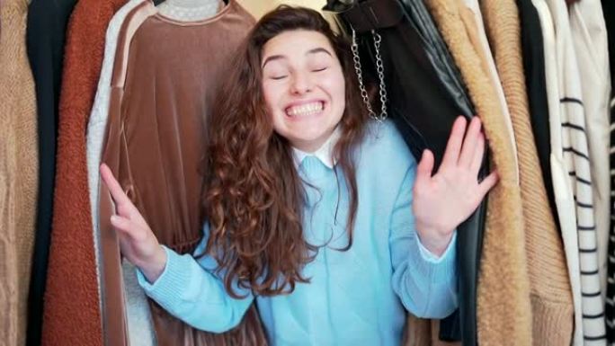 年轻有趣的快乐女孩情绪激动地把头放在架子上，衣服被价格和销售震惊。