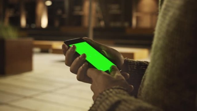使用绿色样机屏幕智能手机的人的手