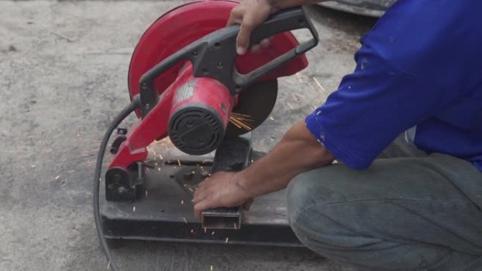 工人用圆钢切割机切割钢材。