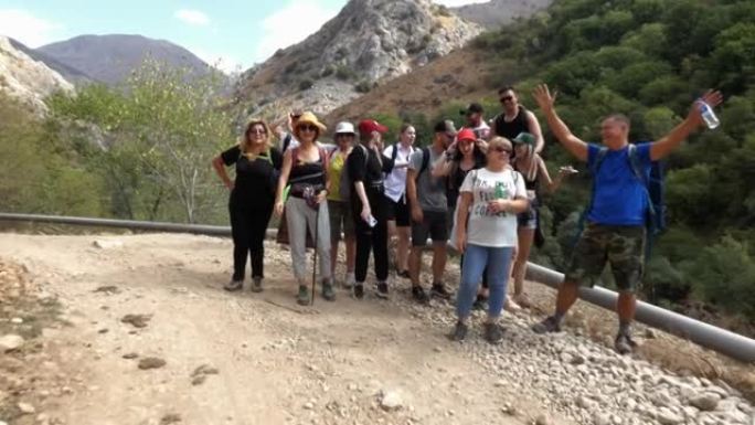 镜头接近一群站在岩石山路上的游客