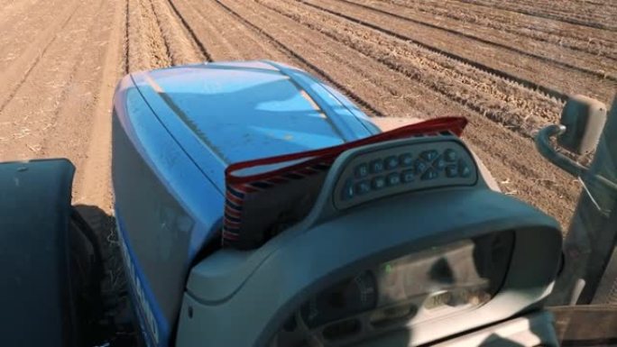 马铃薯收获。马铃薯收割机。农场马铃薯田。从拖拉机驾驶舱观看。特写。马铃薯收获过程。现代农业设备