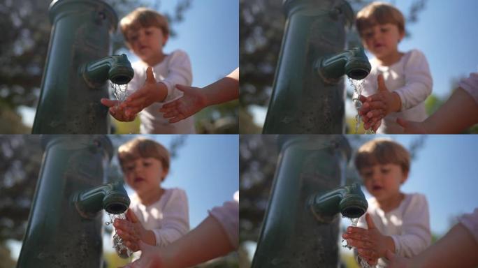 儿童在慢动作中用公共水龙头的清水洗手